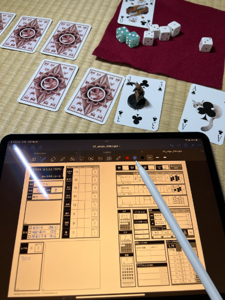 Character sheet on a tablet, with the cards comprising the map and dice behind it.
