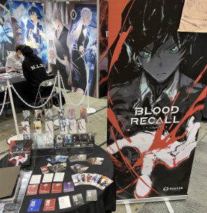 Blood Recall booth banner and cards on a table.