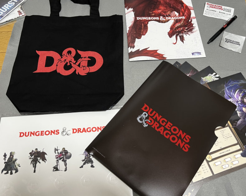 Loot from the D&D booth. Standee characters, character sheets, folder, small tote bag, pen, and sticker.