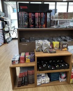 Shelving of various games with a display rack for D&D.
