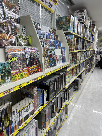 Shelf of TRPG books in the foreground and board games in the background.