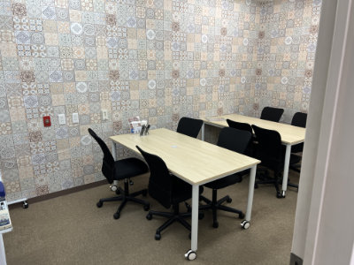 The side room with two rectangular tables. The walls are papered with an Azul motif.