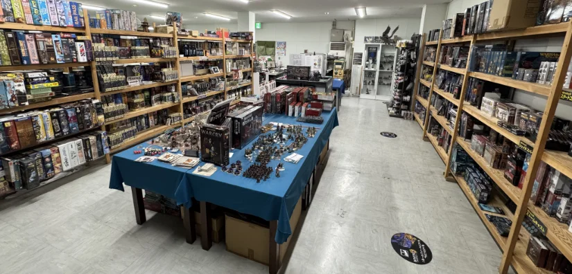 Sales area of Miniature Forest. Tables with samples in the middle with shelves of product on either side.