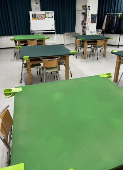 Place area with multiple green felted square tables.