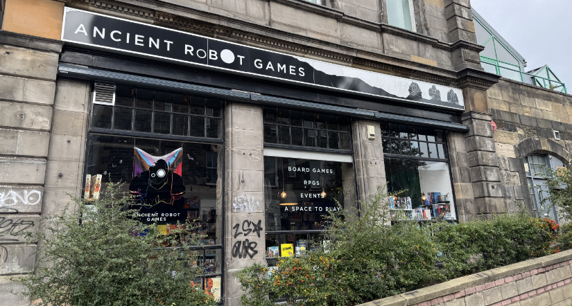 Exterior side of Ancient Robot Games. Large glass windows with shelves of games.