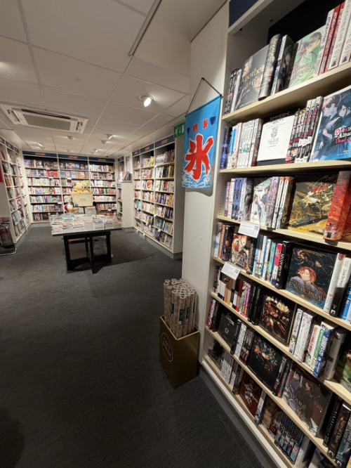 English language manga with a Kamigori wall hanging.