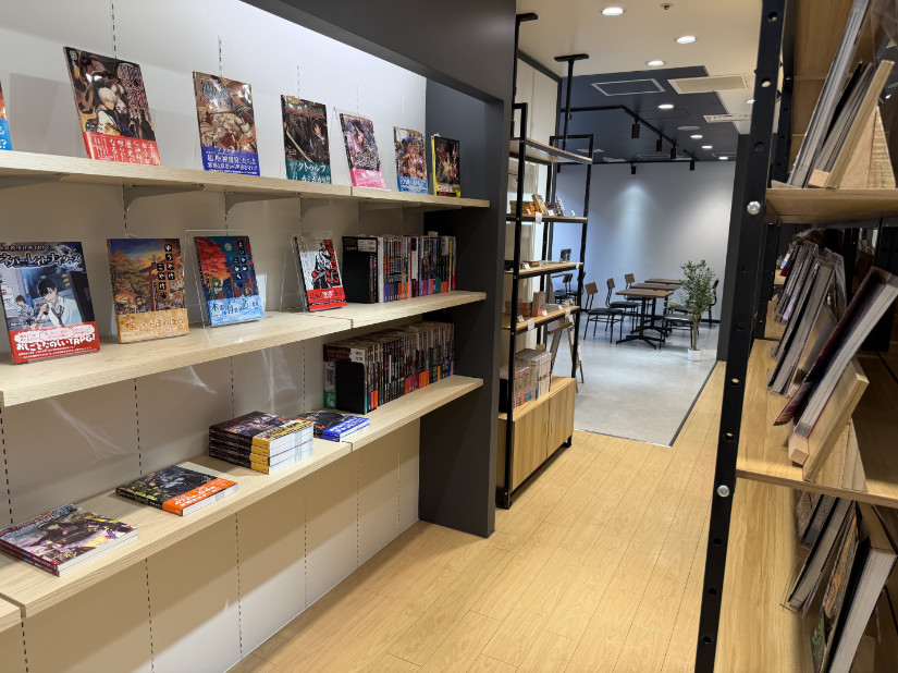 Kamigakari and Yuuyake Koyake, among others displayed on shelves. A pine colored floor leads further back to a seating area.