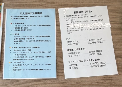 photo of two laminated sheets of paper showing pricing and rules.